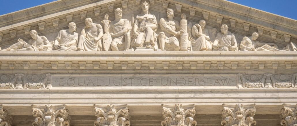 Detailed view of the Supreme Court Building's frontal frieze depicting historical figures and justices.