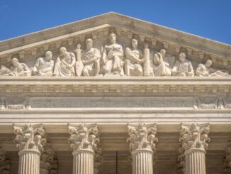 Detailed view of the Supreme Court Building's frontal frieze depicting historical figures and justices.