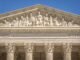 Detailed view of the Supreme Court Building's frontal frieze depicting historical figures and justices.
