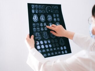 Doctor examines brain MRI scans closely for medical diagnosis in a hospital environment.