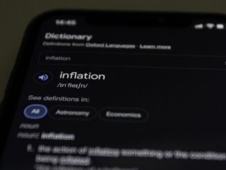 Close-up of a smartphone screen showing the word inflation defined in a dictionary app.