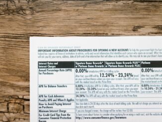 A detailed financial document listing interest rates on a textured wooden table.