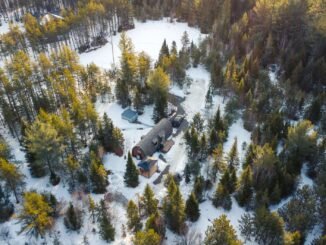 Aerial shot of cabins surrounded by snowy forest in Saint-Alexis-des-Monts, Québec.