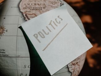 A close-up of a globe with a politics sticky note, symbolizing global political themes.