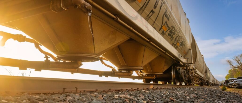 Low-angle view of a freight train with sunlight shining through, captured in Reads Landing, MN.