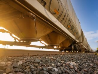Low-angle view of a freight train with sunlight shining through, captured in Reads Landing, MN.