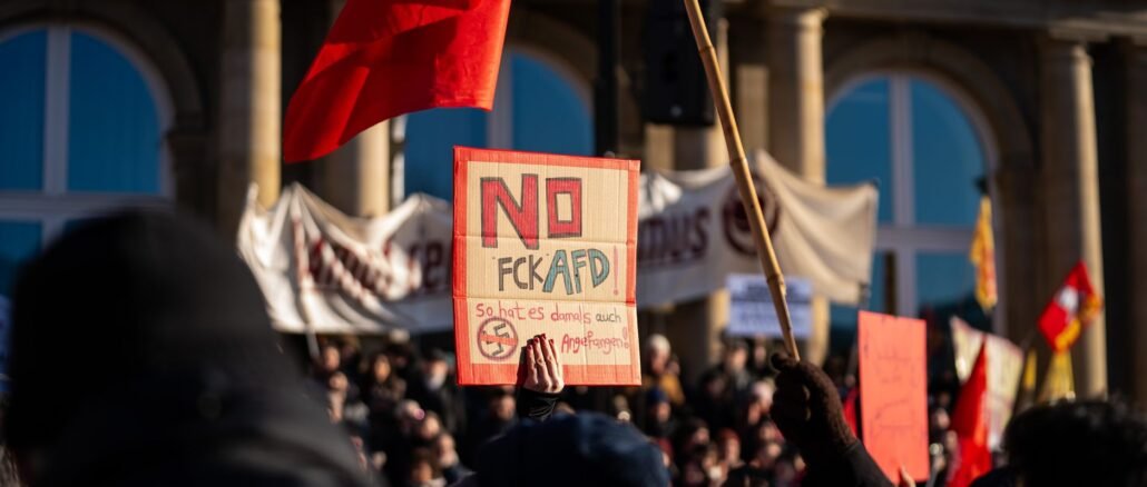 Crowd in Stuttgart demonstrating against AfD with signs and banners.