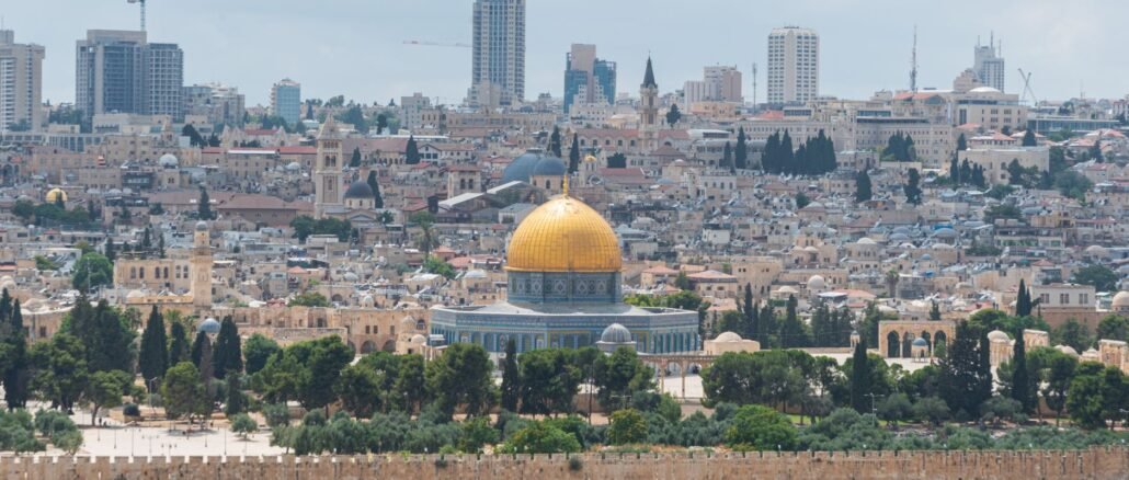 Captivating aerial view of the Dome of the Rock with Jerusalem's skyline in the background.