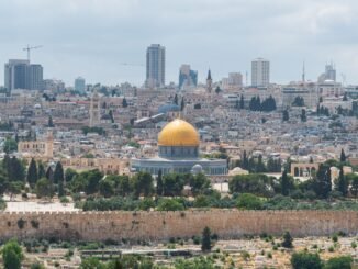 Captivating aerial view of the Dome of the Rock with Jerusalem's skyline in the background.