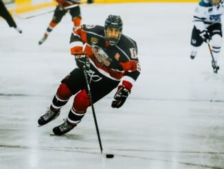 Dynamic action shot of a hockey player skating on an ice rink during a game.