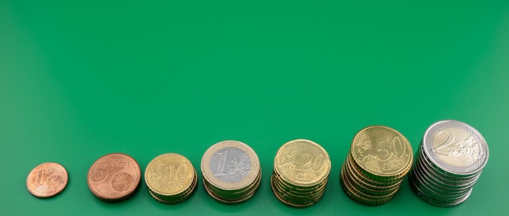 Various euro coins stacked incrementally on a vibrant green background.