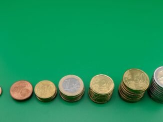 Various euro coins stacked incrementally on a vibrant green background.