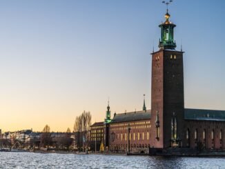Beautiful view of Stockholm City Hall reflecting on the water during sunset, showcasing its iconic architecture.