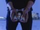 Close-up of handcuffed hands holding rolled cash, suggesting crime or arrest.