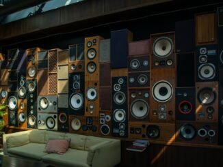 A cozy living room with a striking wall of vintage speakers, showcasing retro audio aesthetics and comfortable seating.