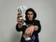 Close-up of a man in handcuffs holding cash and drugs, illustrating crime and illegal activities.
