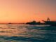 Capture the enchanting Venice sunset, reflecting over calm waters with moored boats.