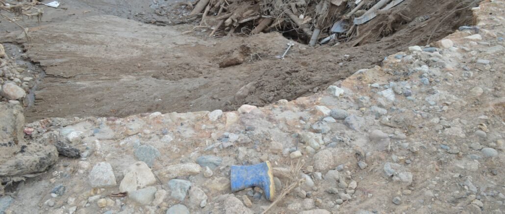 A landscape showing mud, debris, and a lone boot in Mocoa, Colombia's natural disaster aftermath.