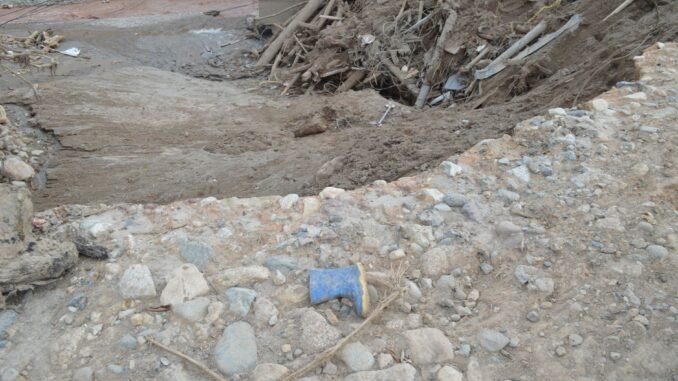 A landscape showing mud, debris, and a lone boot in Mocoa, Colombia's natural disaster aftermath.