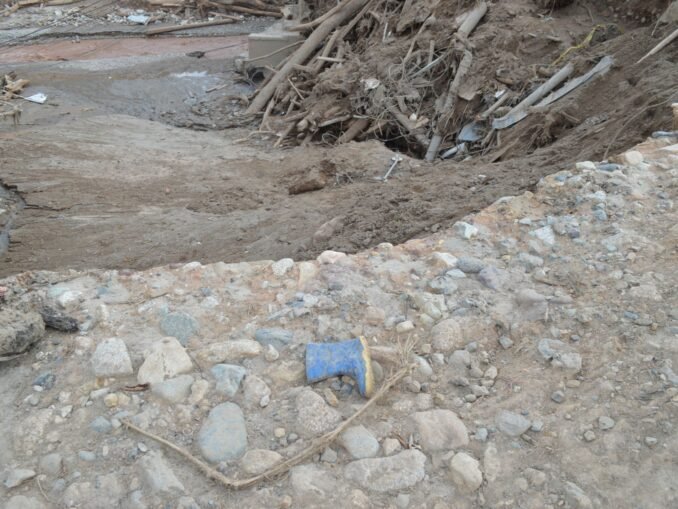 A landscape showing mud, debris, and a lone boot in Mocoa, Colombia's natural disaster aftermath.